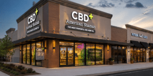 A modern retail storefront featuring an illuminated exterior sign and vibrant window graphics.